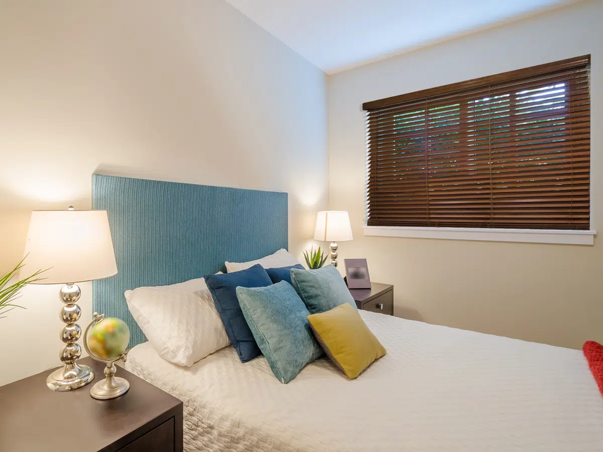 Bedroom window with tailored horizontal wood blinds filtering natural light